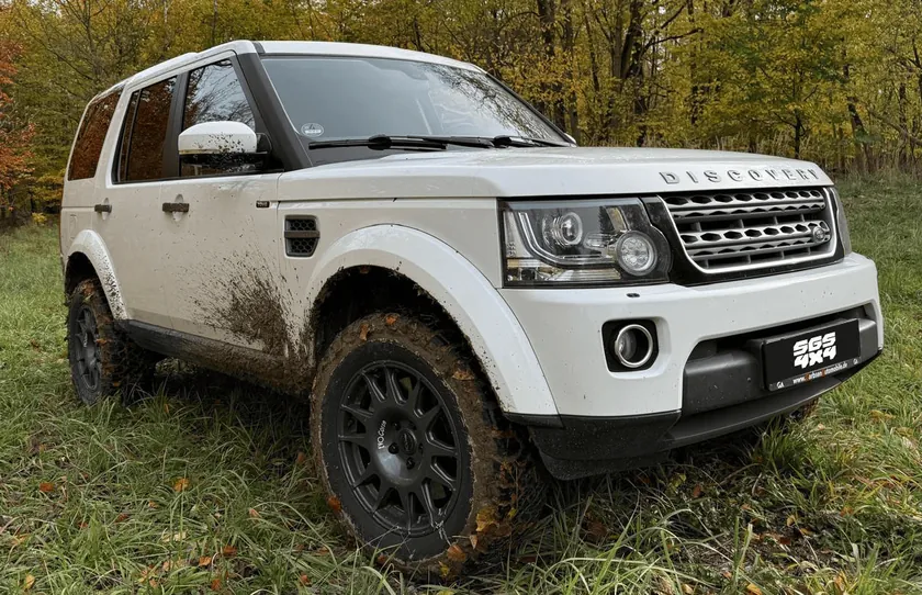 Land Rover Discovery 4 mit schwarzen EVO-Corse-Felgen auf einer Waldwiese