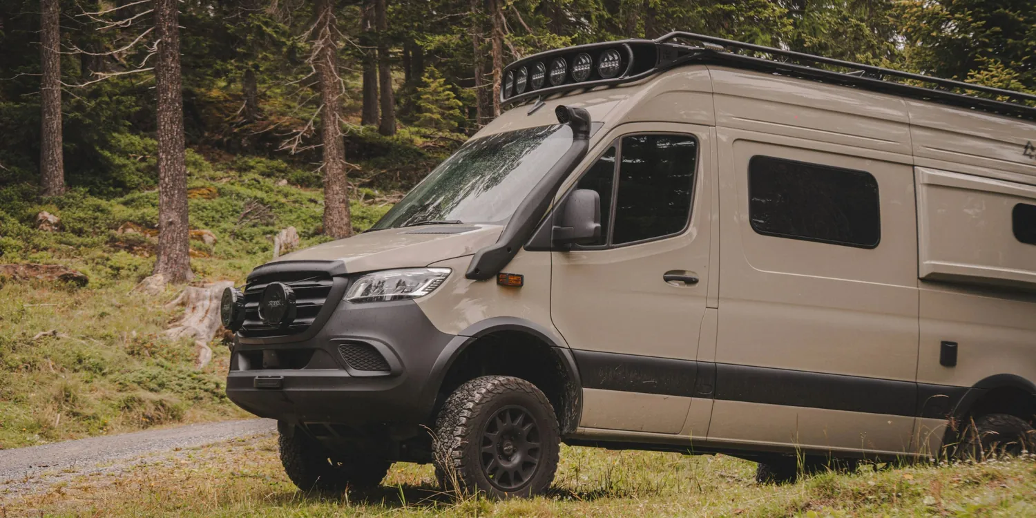 Mercedes Sprinter mit mattschwarzen EVO-Corse-Felgen und Offroad-Bereifung im Wald