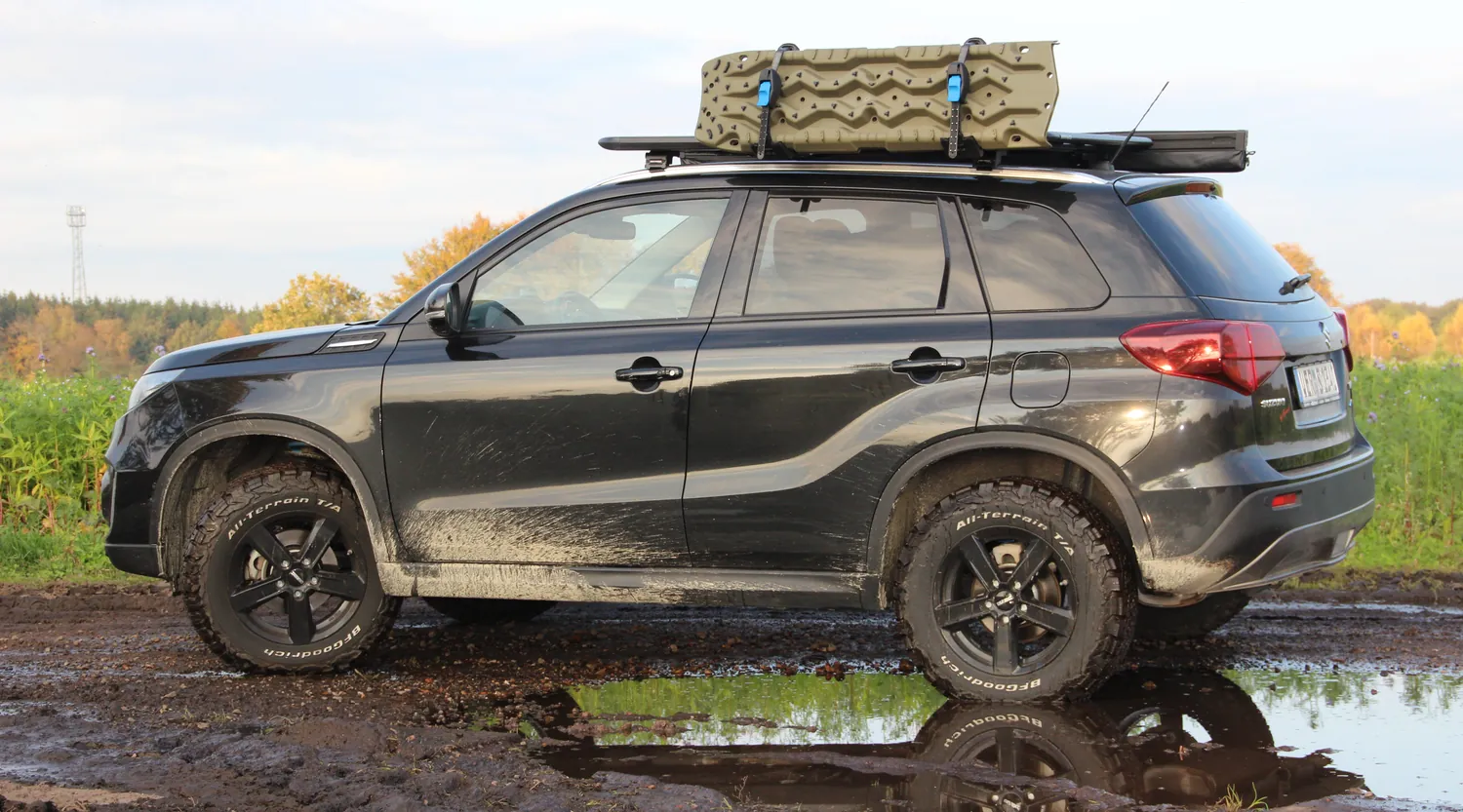 Suzuki Vitara LY mit Höherlegung, All-Terrain-Bereifung und Dachträger in der Seitenansicht